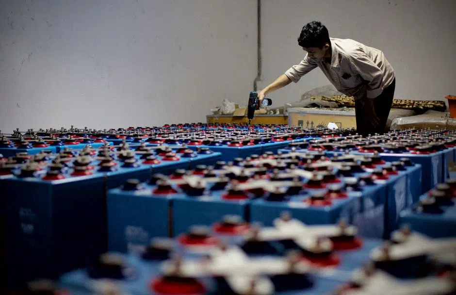 Technicien contrôlant des modules de batterie lithium-ion en usine moderne
