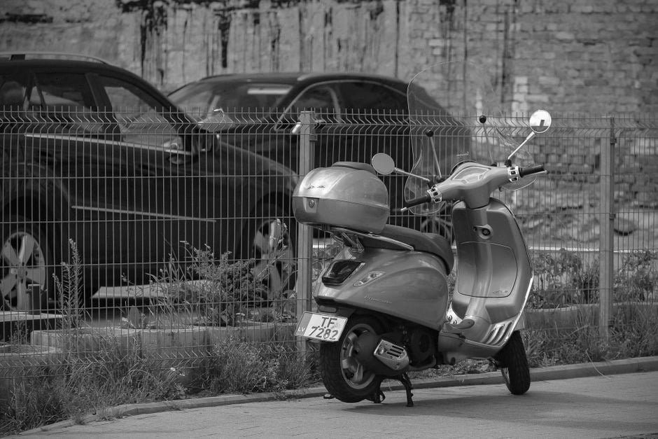Moto électrique branchée près d’une borne de recharge urbaine