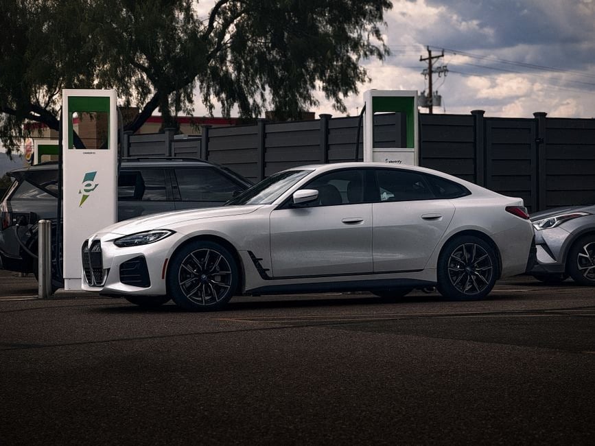 Berline électrique haut de gamme en recharge devant immeubles modernes