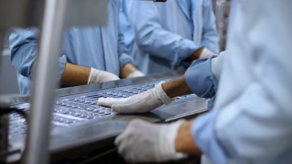 Techniciens contrôlant une chaîne avancée de fabrication de semi-conducteurs